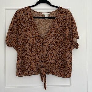 Cheetah print v neck crop top with buttons down the middle and tie knot.